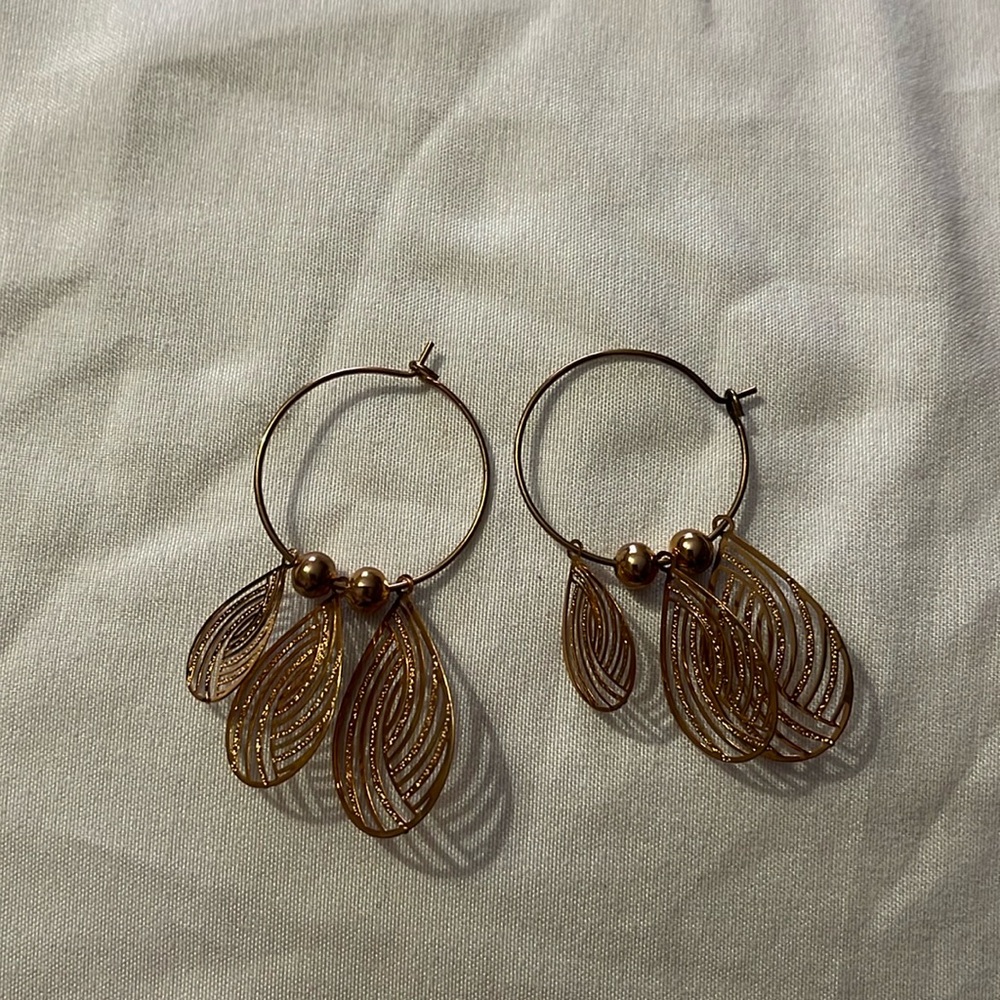 Delicate gold tone hoop earrings with tear drop detail